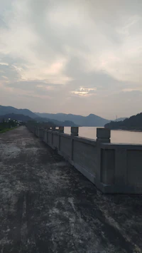 a concrete wall next to a body of water