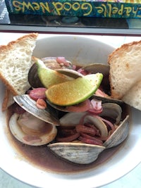 a bowl with clams and bread on it