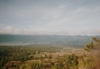 the view from the top of a hill overlooking a lake and mountains