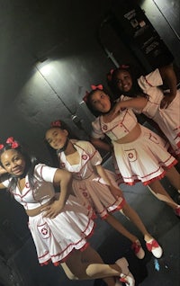a group of girls in white and red outfits posing for a photo