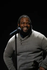 a man with a beard is smiling into a microphone