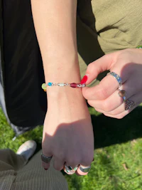 a woman is putting a bracelet on her wrist