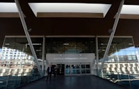 a man is standing in front of a building with a glass roof