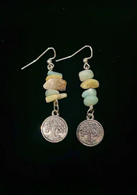 a pair of earrings with a tree of life on them