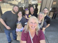 a family is taking a selfie in front of a brewery