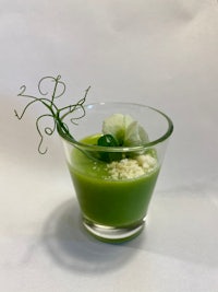 a green drink with a flower on top