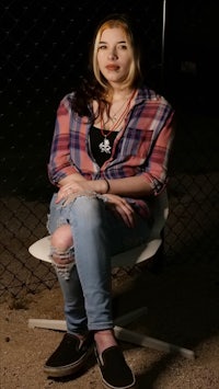 a young woman sitting on a chair at night