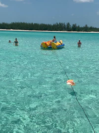 a group of people on a raft in the clear blue water