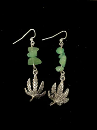a pair of earrings with a marijuana leaf on them