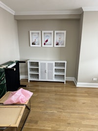 a room with a bed, a dresser, and a few framed pictures