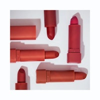 a group of red lipsticks on a white surface