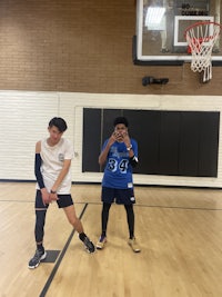 two men standing on a basketball court