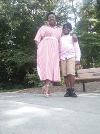 a woman and a boy posing for a picture in a park