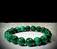 a green malachite stone bracelet on a table