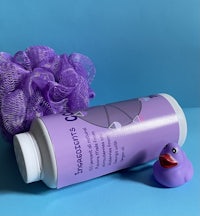 a bottle of shampoo with a purple rubber duck next to it