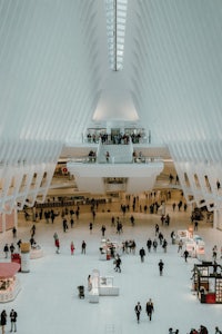 the inside of a large white building with lots of people walking around
