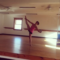 a woman doing a yoga pose in a room with mirrors