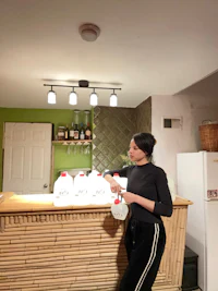 a woman standing in front of a bamboo bar