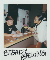 two people sitting at a table talking to each other