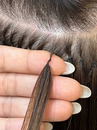 a person's hand is holding a piece of hair