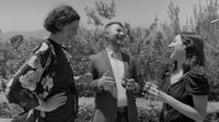 three people talking in a black and white photo