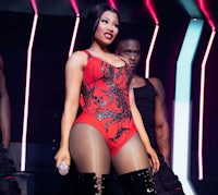 nicki minaj performs on stage in a red outfit with thigh high boots