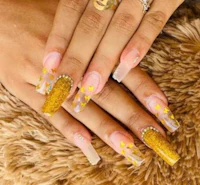 a woman's hand with gold nails and a gold ring