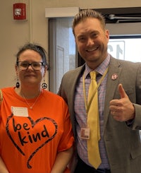 two people standing next to each other with a be kind t - shirt