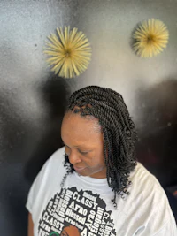 a woman wearing a t - shirt looking at her hair
