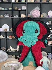 a stuffed octopus is sitting in front of a display of rocks
