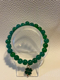 a green jade bracelet with a clover charm