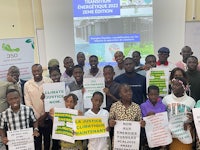 a group of people holding signs in front of a screen