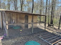 a chicken coop in a wooded area