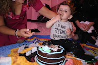 a woman feeding a baby a cake