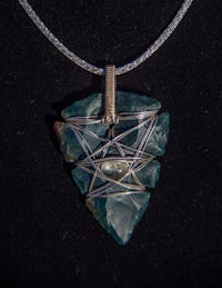 a necklace with a green stone and a silver chain