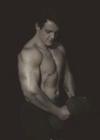 a man posing with a pair of dumbbells