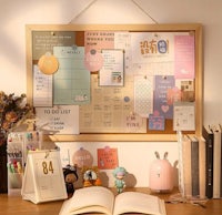 a desk with an open book and a bulletin board