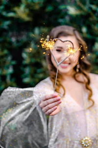 a girl holding a sparkler with a heart shape
