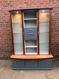 a grey and wood curio cabinet with glass doors