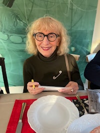 a woman with glasses sitting at a table