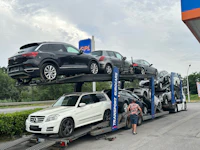 a man loading cars onto a flatbed truck