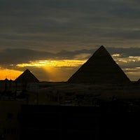 the sun rises over the pyramids in giza, egypt