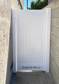 a white gate in front of a brick wall