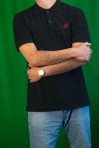 a man wearing a black polo shirt and jeans