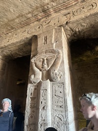 a group of people looking at carvings in a temple