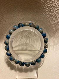 a blue and gray stone bracelet on a table