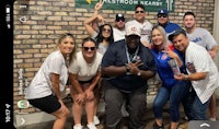 a group of people posing for a picture in front of a wall