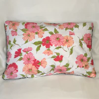 a pink and green floral pillow on a white background