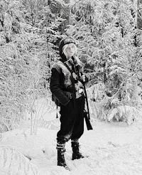 a man with a rifle standing in the snow