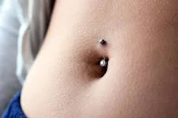 a close up of a woman's stomach with a piercing